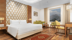 An image of our Deluxe Room with a double bed, a writing desk and a carpeted floor - Sarovar Premiere, Srinagar 